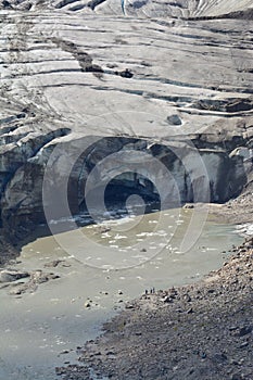 Vertical shot of an Icelandic glacier tongue with glacier gate and meltwater river