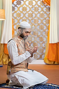 Vertical shot of indian muslim man doing holy namaz or Salah at home during ramdan festival - concept tredition, culture