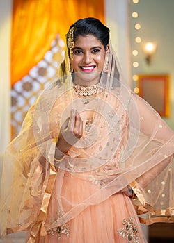 Vertical shot of Indian Muslim woman traditional ethic wear during ramadan festival celebration looking at camera -