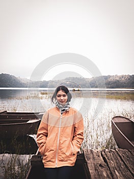 Vertical shot of an Indonesian female by the Tamblingan lake on a foggy day