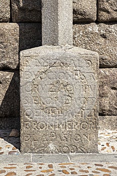 Vertical shot of the inscription in the base of a cross in the Roman aqueduct. Segovia, Spain.