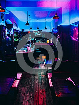 Vertical shot of an interior of a pub with blue and purple lights