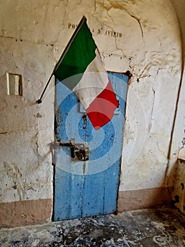 Vertical shot of Italy's flag over an old blue door