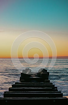 Vertical shot of a jetty at Rehoboth Beach with a mesmerizing view of the sunrise in Rehoboth, US