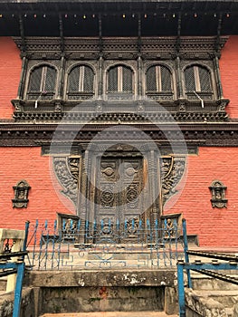 Vertical shot of the Kumari Ghar temple with intricately carved doors and windows in Nepal photo