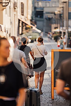 Vertical shot of a lady talking on mobile and walking in a crowded street