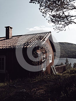 Vertical shot of a lake house in the middle of a forest under the clear sky