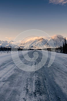 Vertical shot of a landscape with trees and mountains covered in snow in Whitehorse, Yukon, Canada