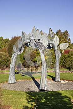 Vertical shot of Large steel Sculpture named Entwined with copper patina by Chris Moore in Auckland Botanical Gardens
