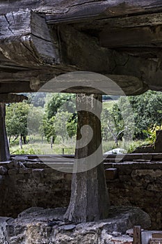 Vertical shot of a large vertical megalith supporting an old wooden house