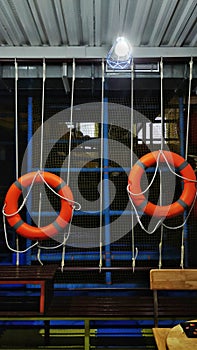 Vertical shot of lifeguard ring buoys hanging on a rope