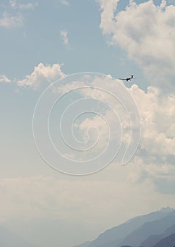 Vertical shot of a light aircraft flying into the sky over the silhouettes of mountains