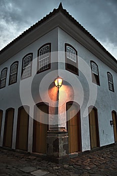 Vertical shot of a lit lamp on a building corner in Paraty, State of Rio de Janeiro, Brazil