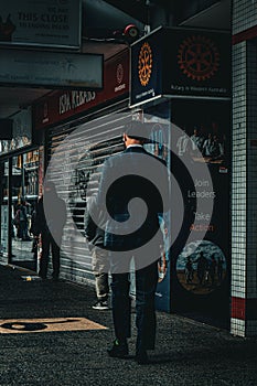 Vertical shot of a male in a formal suit walking in downtown Perth, Australia