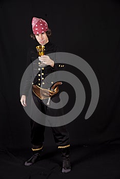 Vertical shot of a male in a pirate costume drinking from a golden glass