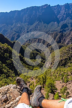 Vertical shot of male's feet and the La Cumbrecita National Park in the Canary Islands, Spain