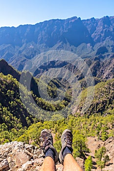 Vertical shot of male's feet and the La Cumbrecita National Park in Canary Islands, Spain