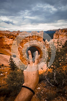 Vertical shot of a man's hand showing peace sign in Bryce Canyon National Park, Tropic USA