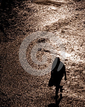 Vertical shot of a man walking in the rainy street