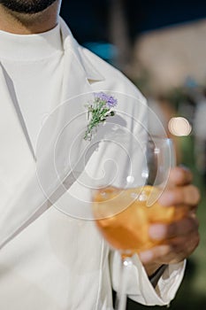 Vertikálne z muž nosenie biely oblek držanie pohár piť na udalosť 