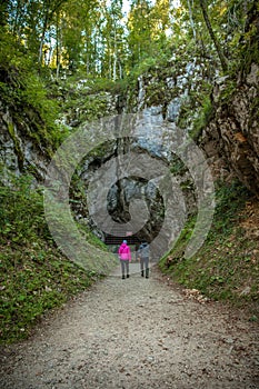 Vertical shot of a man and a woman near the Krizna cave in Slovenia