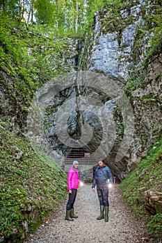 Vertical shot of a man and a woman near the Krizna cave in Slovenia