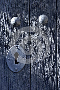 Vertical shot of a metal keyhole on the wooden door