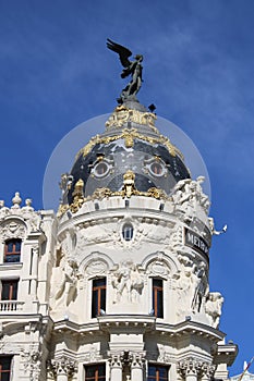 Vertical shot of the Metropolis Building under the sunlight and a blue sky in Madrid, Spain