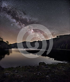 Vertical shot of the Milky Way in the sky over Vir dam in the Czech republic