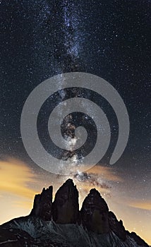 Vertical shot of the Milkyway over the mountain Tre Cime di Lavaredo in Italian Alps