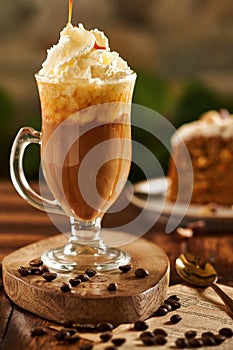 Vertical shot of a mochaccino with whipped cream topping arranged on a wooden surface