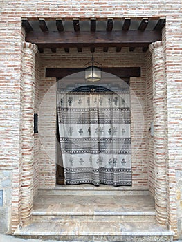 Vertical shot of a modern house facade with brick-made walls and a curtained doorwa