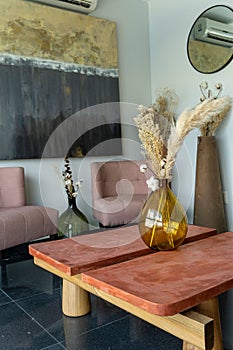 Vertical shot of a modern room with furniture pieces in beige colors and glass vases for decorations