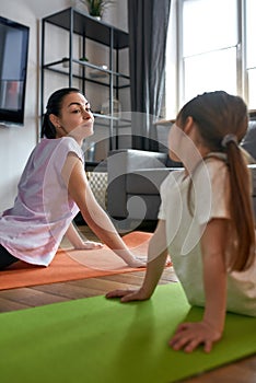 Vertical shot of mom and daughter do stretching together