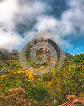 Vertical shot of the Mount Beerwah surrounded by clouds in the daylight