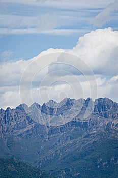 Vertical shot of the mountain range of the Venetian prealps under think clouds photo