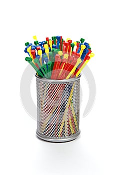 Vertical shot of multicolor nylon cable ties in a jar isolated on white background