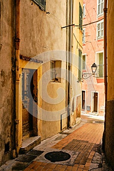 Vertical shot of a narrow alley and buildings captured in Menton, French Riviera, France