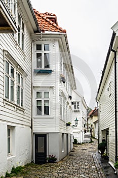 Vertical shot of a narrow cozy street with typical wooden houses in Bergen, Norway