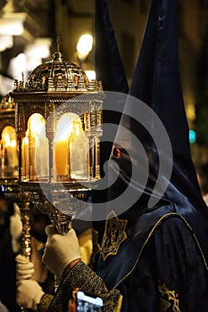 Vertical shot of Nazareno with a black capirote hat during the festivity of holy week in Granada photo