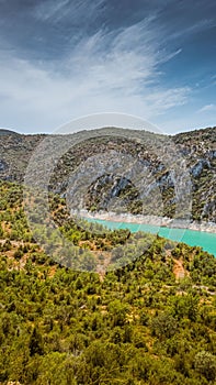 Vertical shot of the Noguera Ribagorzana river with a cloudy blue sky in the background, Spain photo