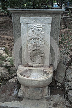 Vertical shot of an old ancient stone-made fountain with a faucet in Athens, Greece