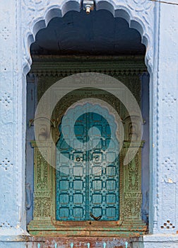 Vertical shot of an old blue door in Indian-style decorations