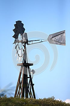 Vertical shot of old farm windmill on blue sky background