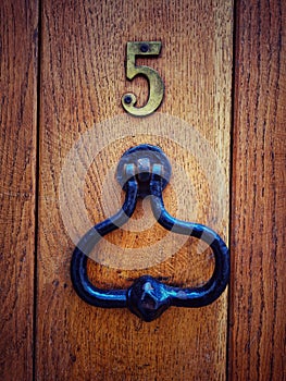 Vertical shot of an old handle door knob on a wooden door number 5