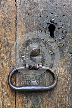 Vertical shot an old metal door knocker with a keyhole on the side