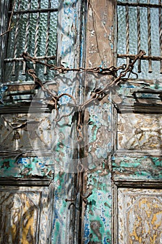 Vertical shot of an old weathered door locked with rusted chains