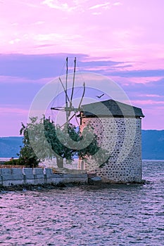 Vertical shot of an old windmill against a scenic sunset