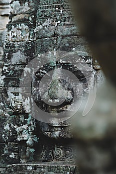 Vertical shot of one of the detailed faces of Bayon Temple in Siem Reap, Cambodia