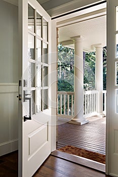 Vertical shot of an open, wooden front door photo